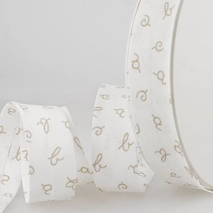 Biais blanc lettres ABC taupe 25mm au mètre Biais blanc lettres ABC taupe 25mm au mètre